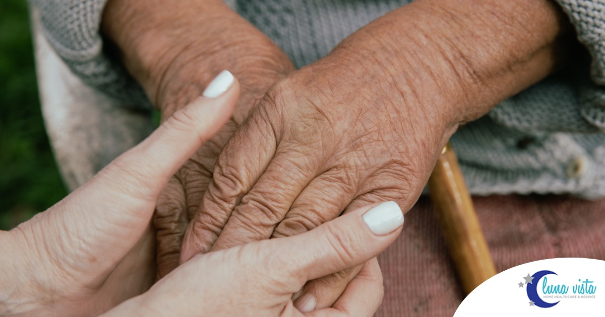 A caregiver holding an older adult's hands represents the support that hospice care can bring.