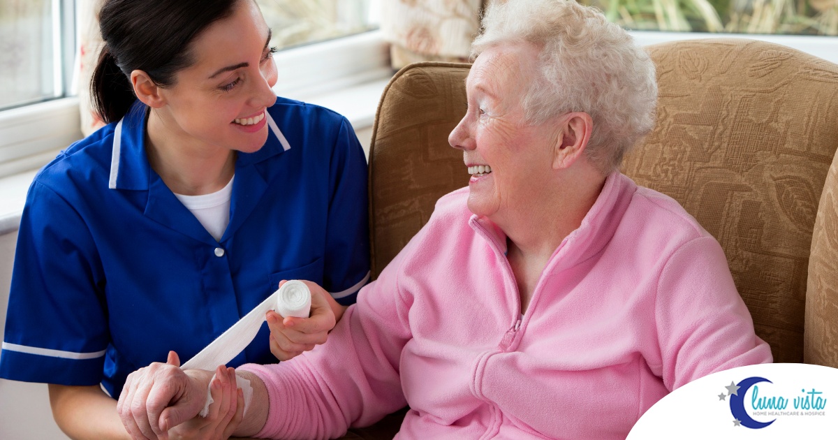 A caregiver demonstrates wound care by wrapping a senior client’s wound.