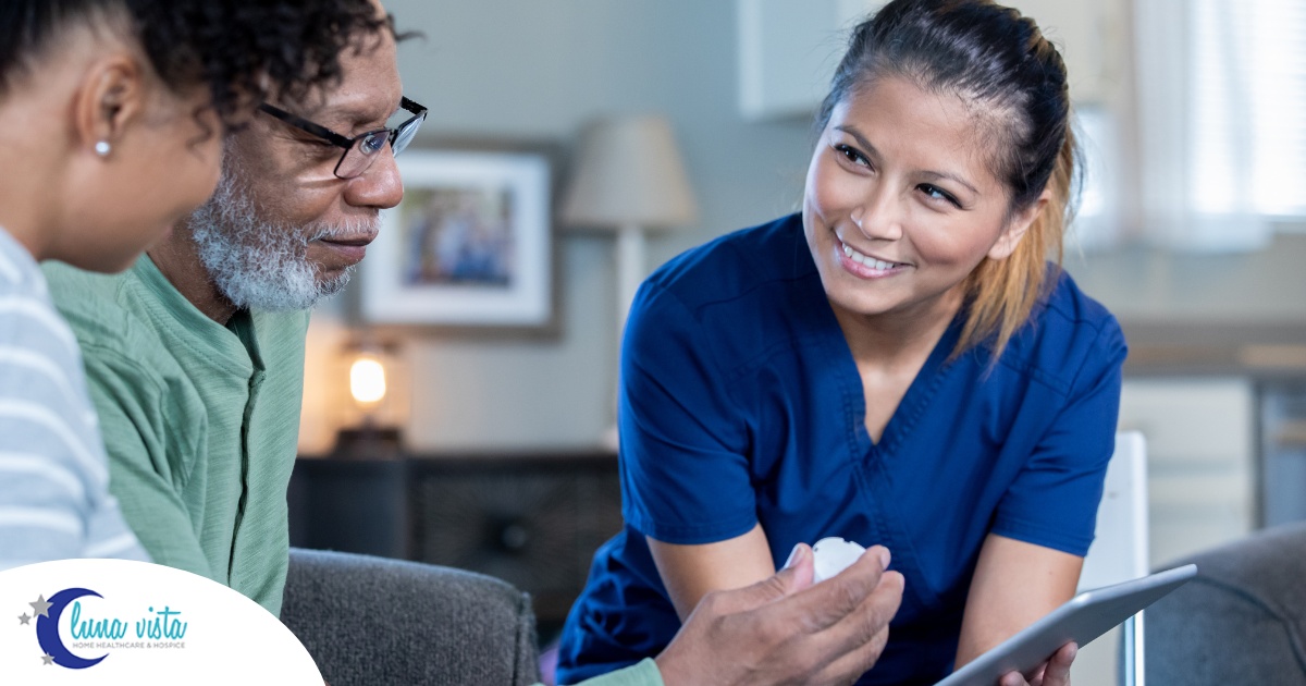 A nurse smiles as she helps an older couple with their medication in the comfort of their own home, showing the benefits of in-home nursing services.